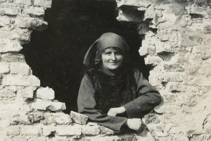 Mairi Chisholm looking through a shell hole, nd.Credit: The National Library of Scotland, Acc.8006