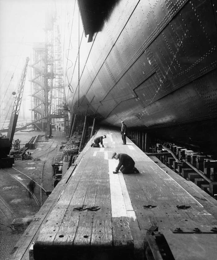 Workmen preparing the launching ways of the Cunard Line ocean liner Queen Mary