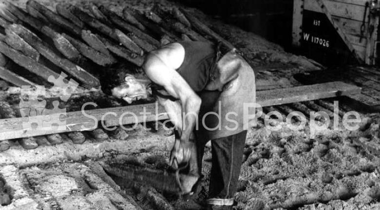 Workman breaking ingots from mould, Carron Works, 20th century