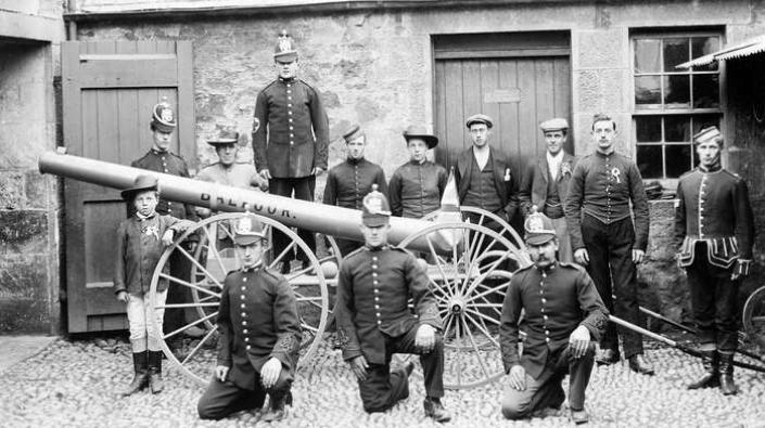 Volunteer firemen and estate workers with a pump mounted on wheels, c 1905