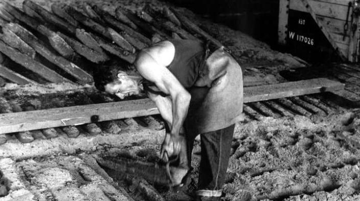 Workman breaking ingots from mould, Carron Works, 20th century