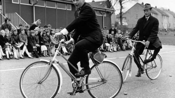 Actors Peter Byrne and Geoffrey Adams riding bicycles, 1967