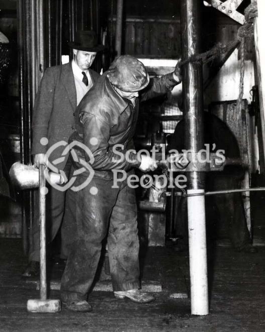 Men removing drilled core on boring tower in the Forth, 1955 Men removing drilled core on boring tower in the Forth, 1955