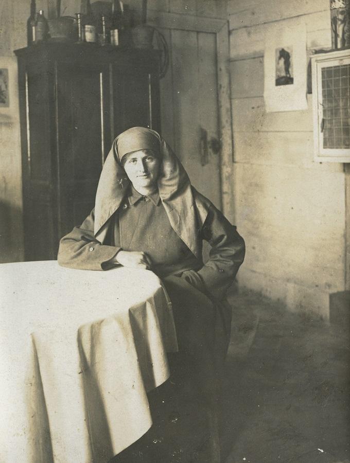 Mairi Chisholm at a table in Pervijze House, nd. Credit: The National Library of Scotland, Acc.8006