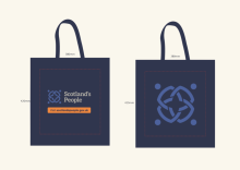 An image of the front and back of a navy tote bag, with the Scotland's People logo and dimensions.