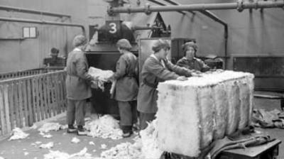 A photograph of four female workers breaking cotton waste bales at HM Munitions Factory, Gretna, [1918].