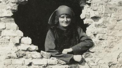 Mairi Chisholm looking through a shell hole, nd.  Credit: The National Library of Scotland, Acc.8006