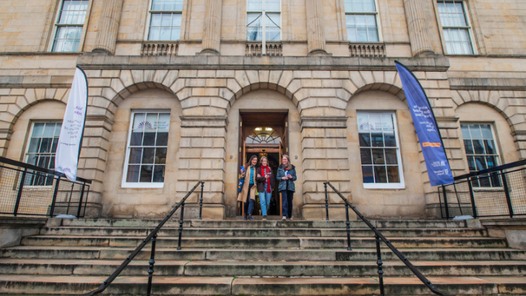 The outside of General Register House in Edinburgh with three women at the top of the stairs leaving the building