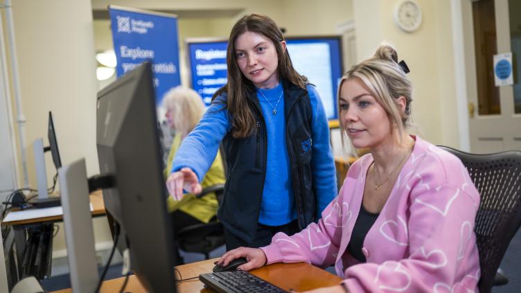 A member of staff is helping a customer during the Family History Course
