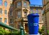 An image of a travel cup with the Scotland's People logo, positioned in a garden