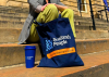 An image of a travel cup and a tote bag in navy, both branded with the Scotland's People logo
